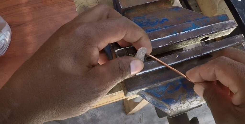 Wrapping a quartz crystal point with copper wire using a workbench